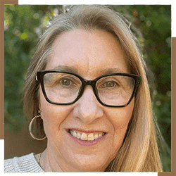 A woman with glasses smiling for the camera.